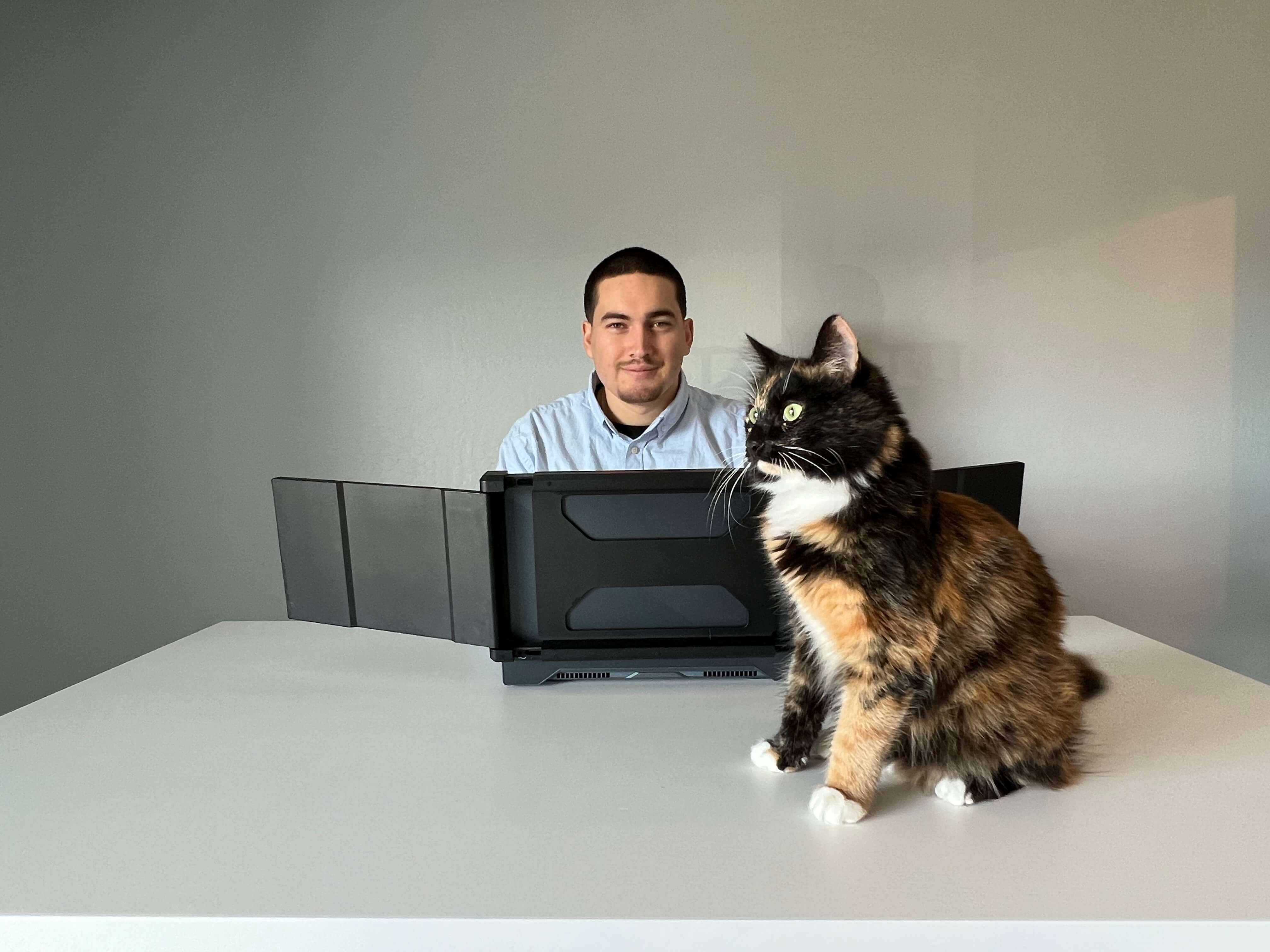 Pablo Padilla at his desk with a cat
